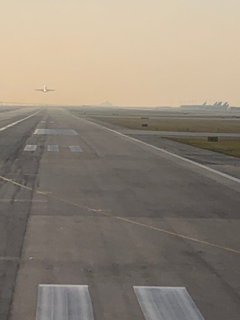an airplane flying over a runway