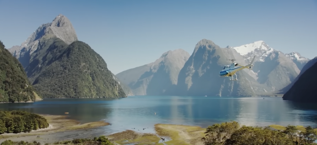 a helicopter flying over Milford Sound
