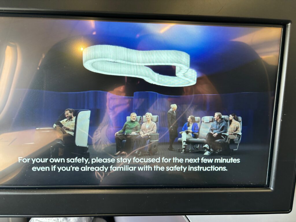 a screen with a picture of people sitting on seats