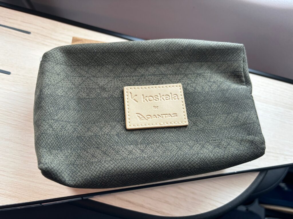 a small grey bag with a tan label on it