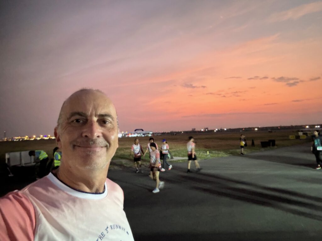a man taking a selfie with people running