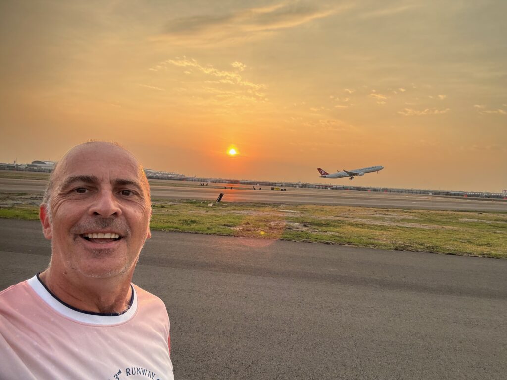 a man taking a selfie with an airplane in the background