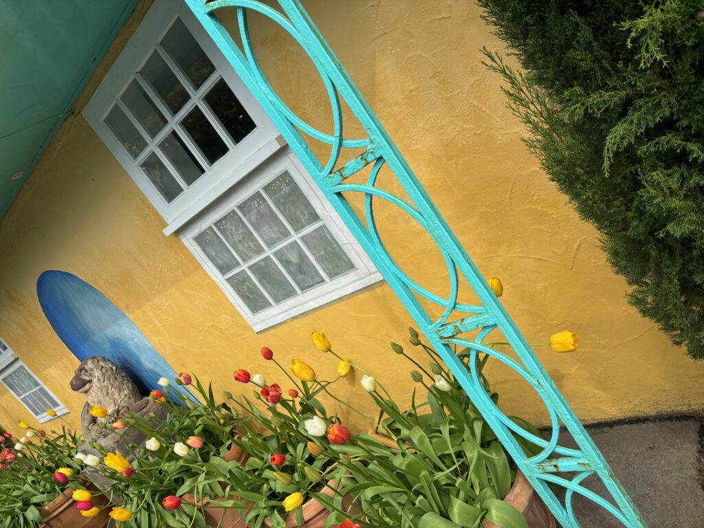 a blue metal railing next to a yellow house