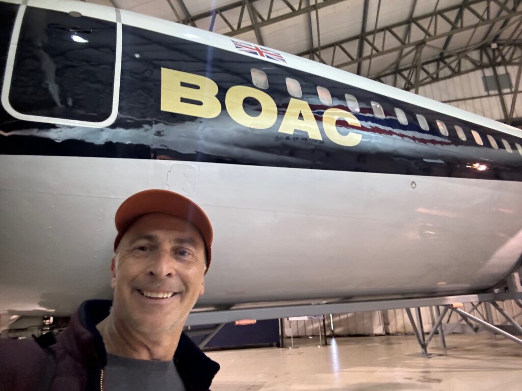 a man taking a selfie in a hangar
