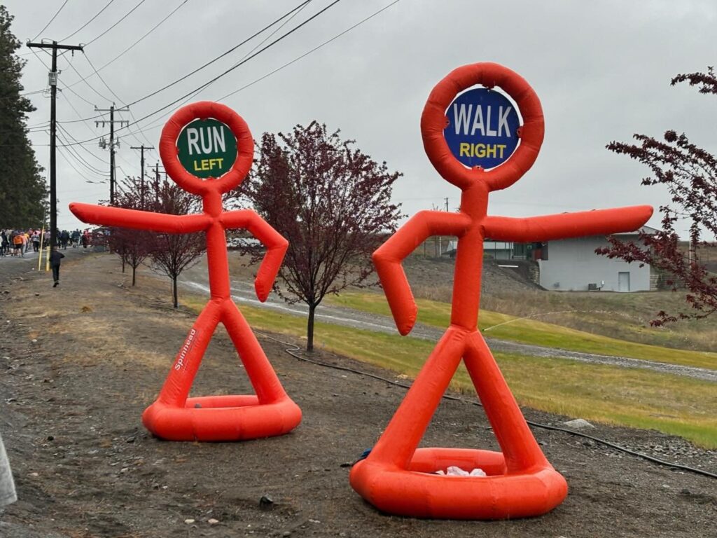 two inflatable figures on a dirt road