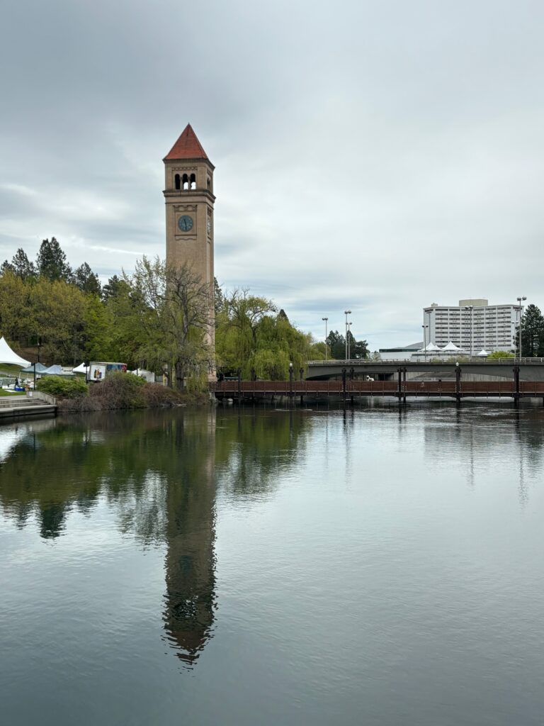 a clock tower next to a body of water