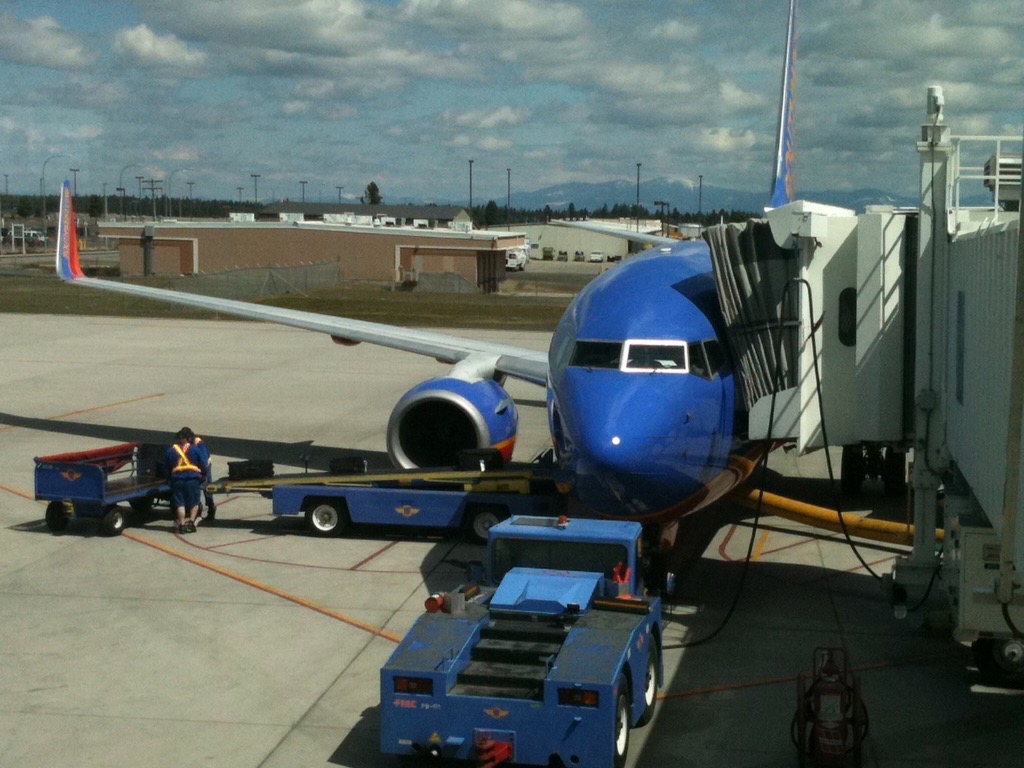 a blue airplane with a blue vehicle on the ground