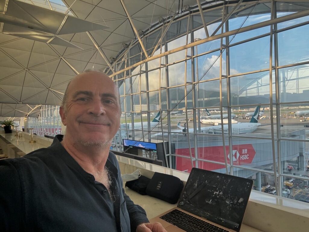 a man sitting in front of a window with a laptop