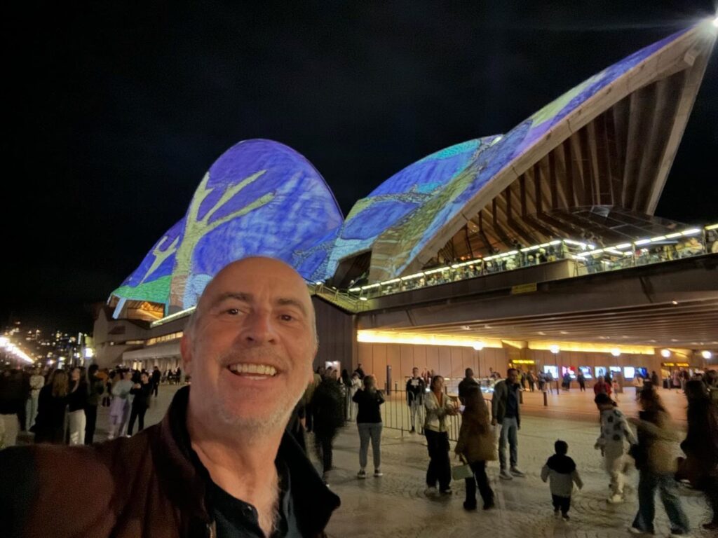 a man taking a selfie in front of a large building