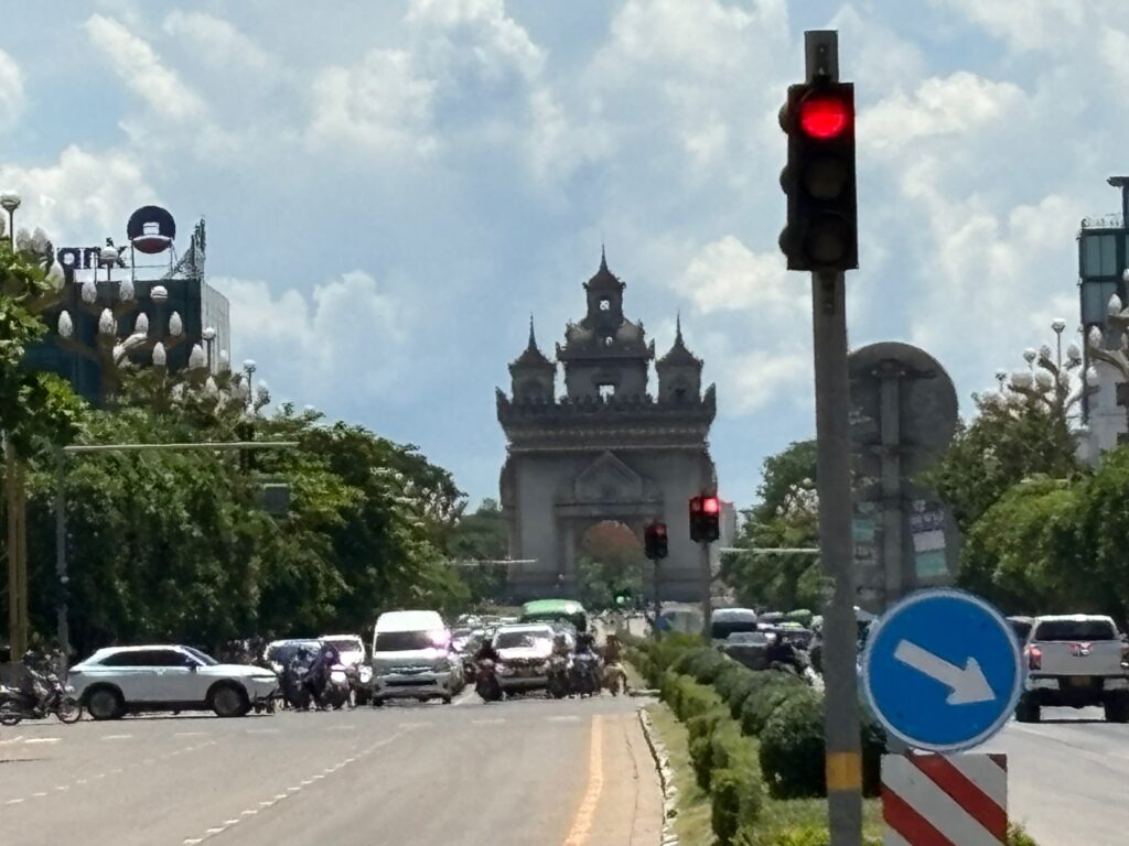 a traffic light on a road with a building in the background