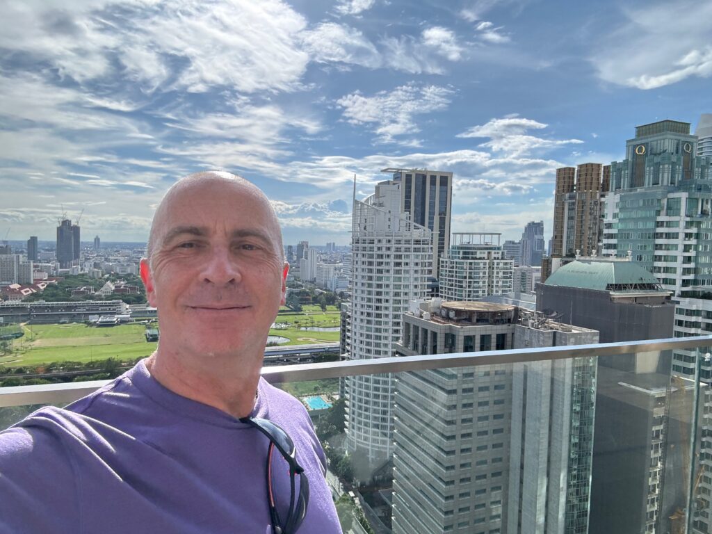 a man taking a selfie with a city in the background