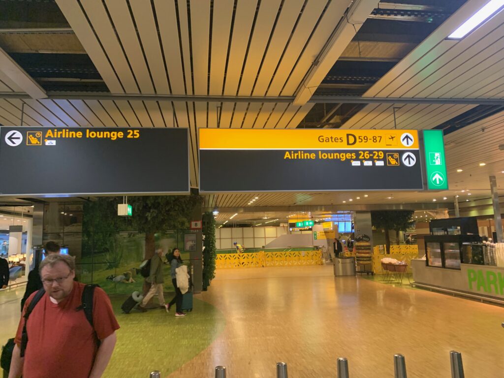 people in an airport with signs and people walking