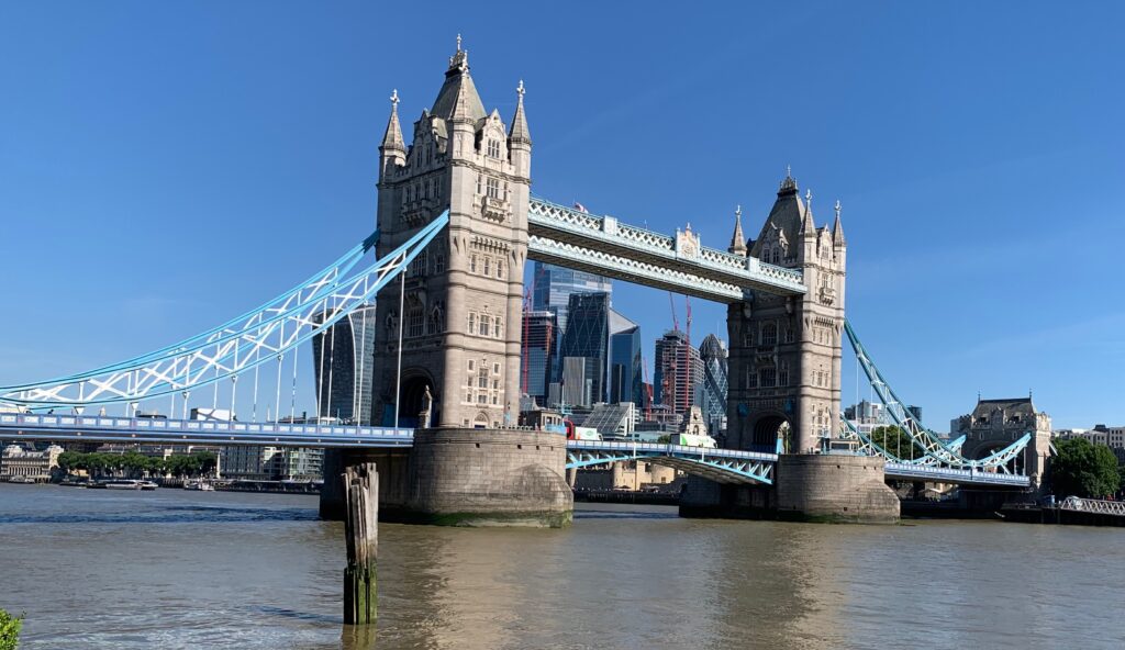 a bridge over water with a city in the background