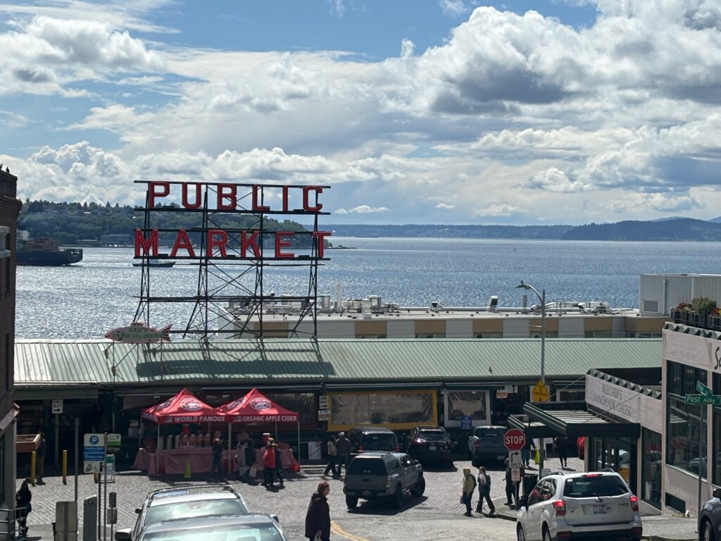 a market with a large sign and a body of water