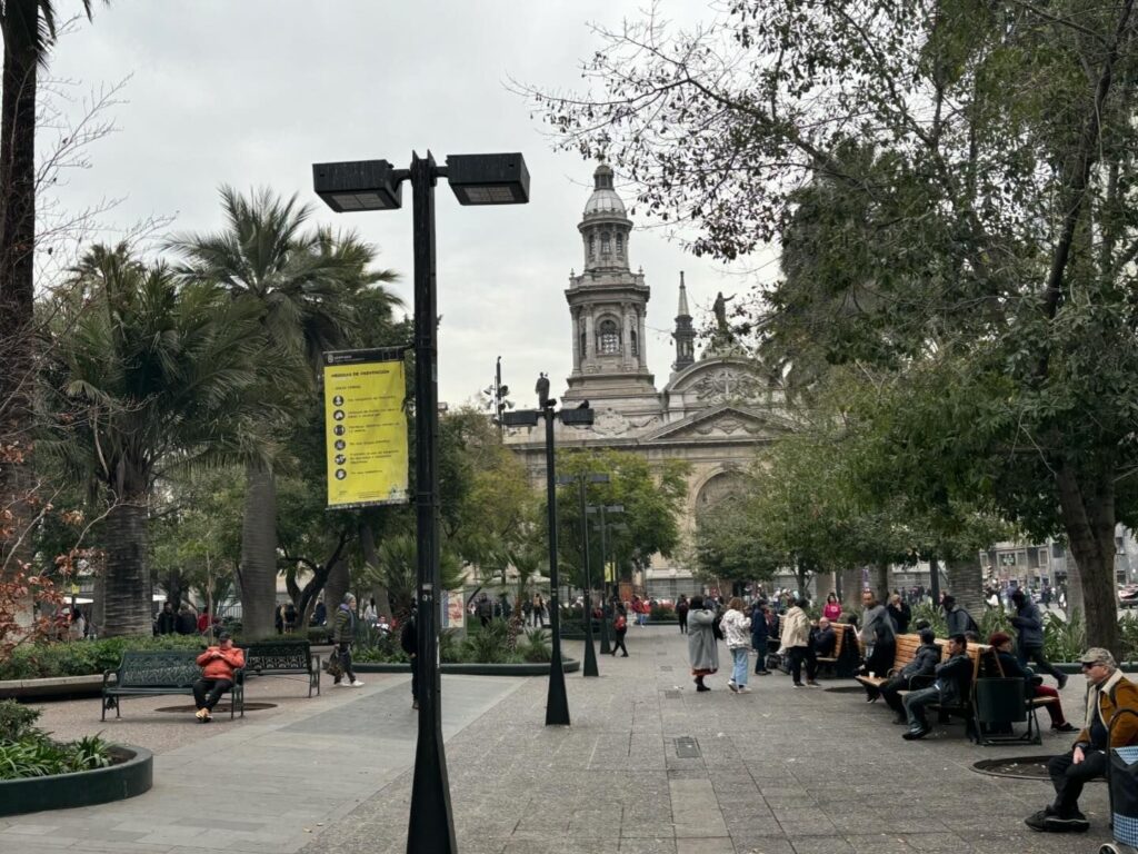 a group of people sitting on benches in a park