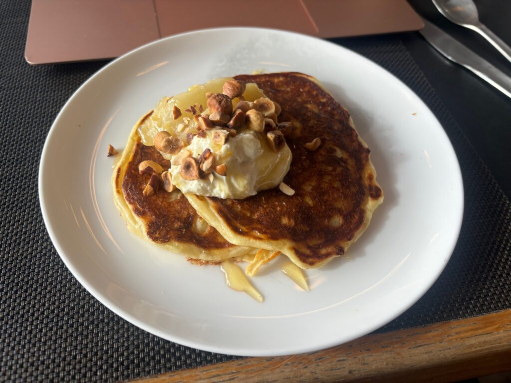 a plate of pancakes with butter and nuts