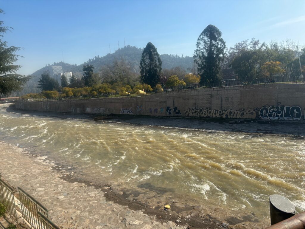 a river with a stone wall and trees