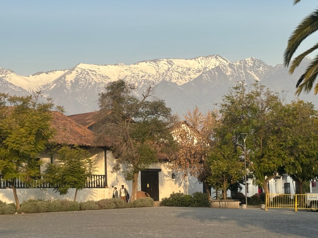 a white house with trees and mountains in the background