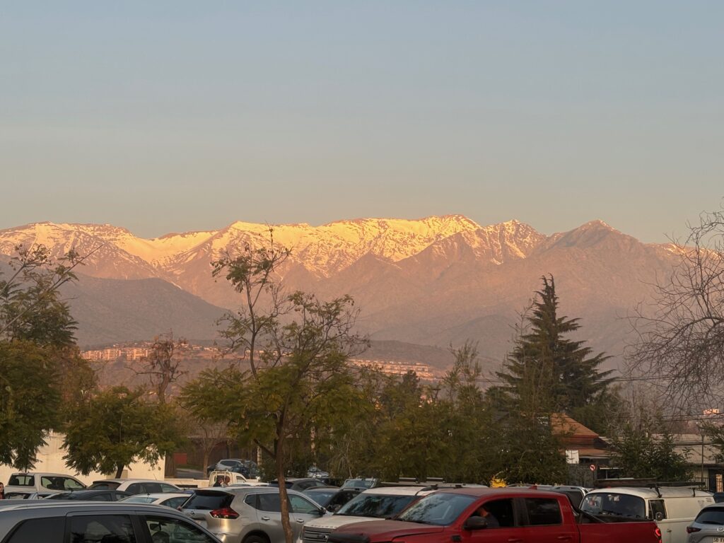 a parking lot with trees and mountains in the background