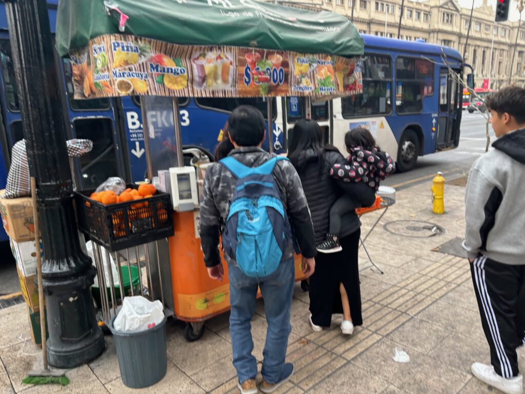 a group of people standing next to a food cart