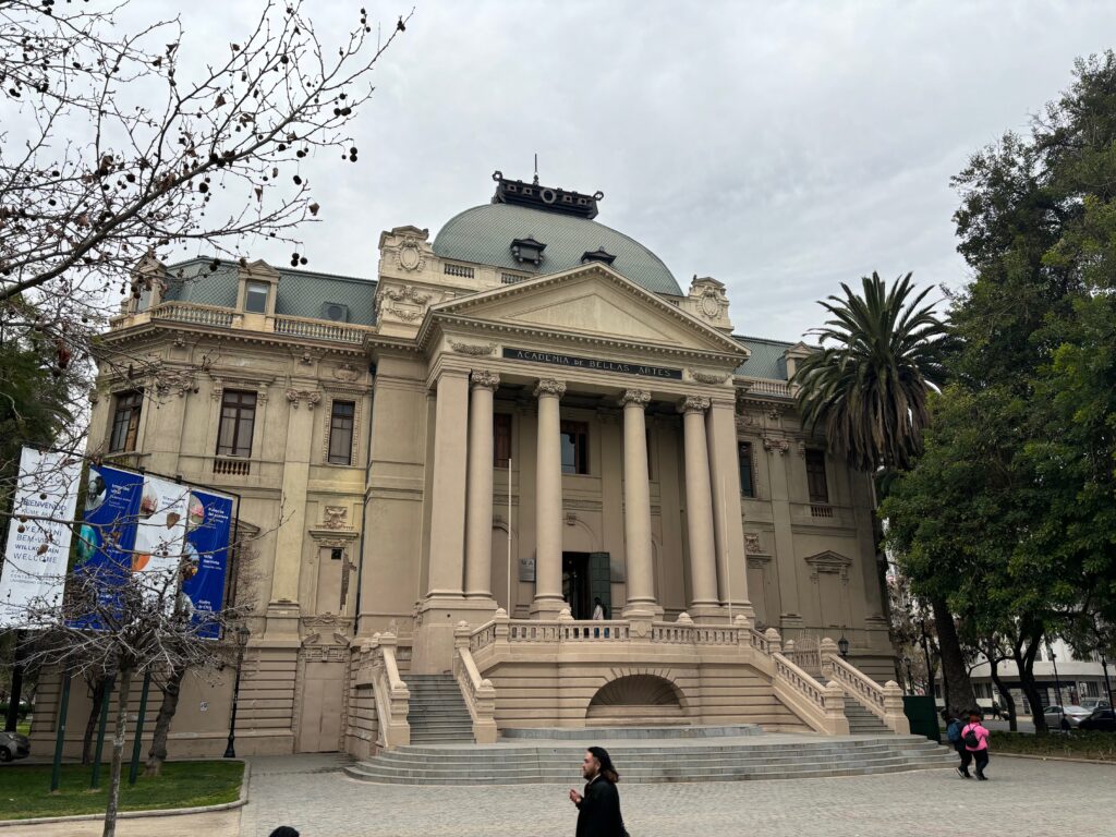 a building with columns and a woman standing in front of it