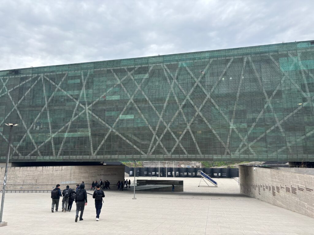 a group of people walking in front of a large building