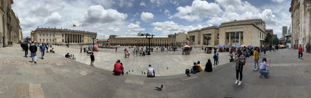 a group of people sitting on a stone surface in a plaza