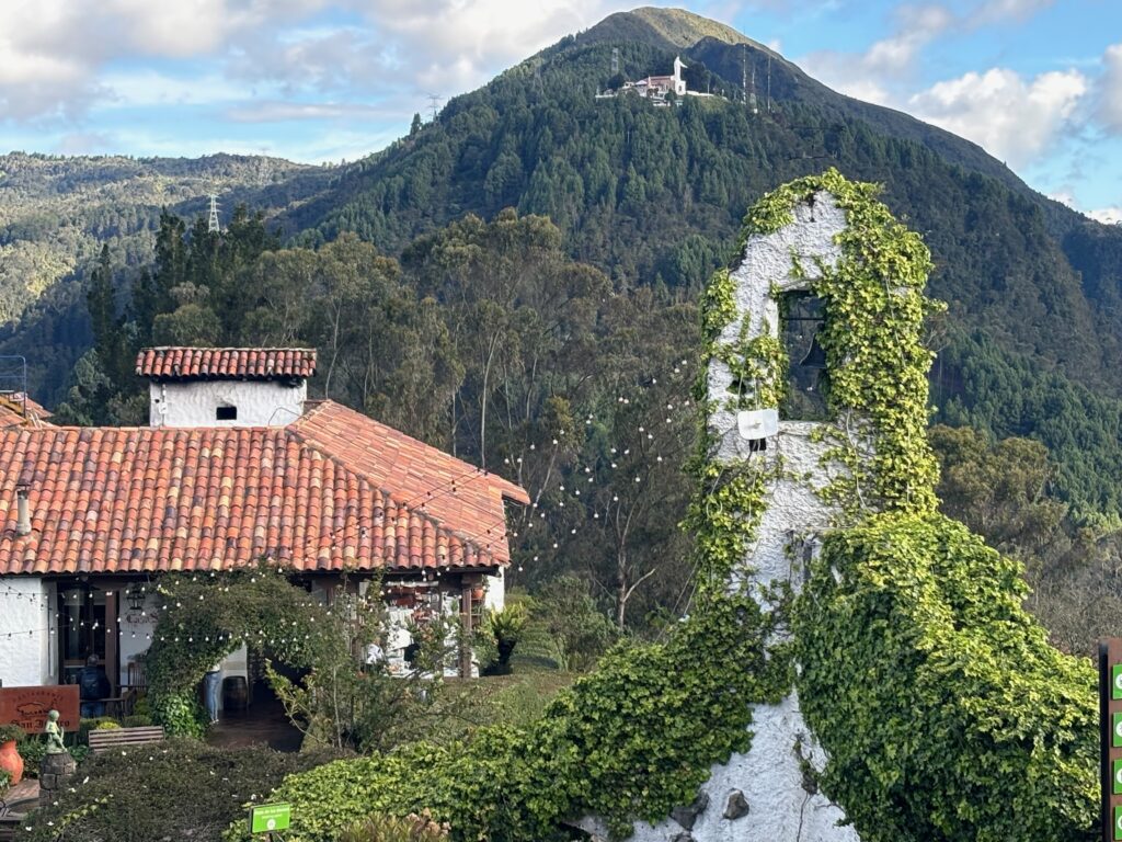 a building with a bell tower and a mountain in the background