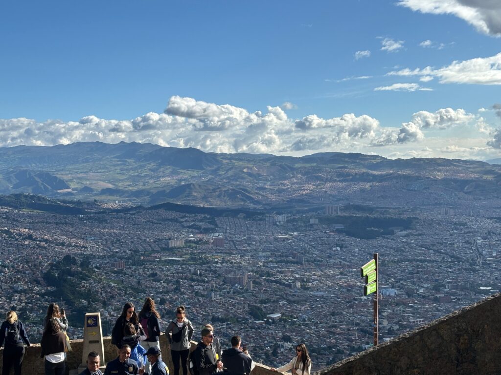 a group of people standing on a ledge overlooking a city