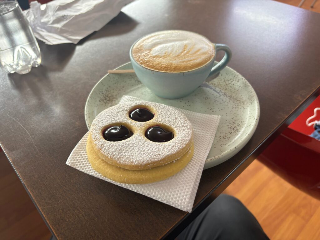 a plate with a cookie and a cup of coffee on a table