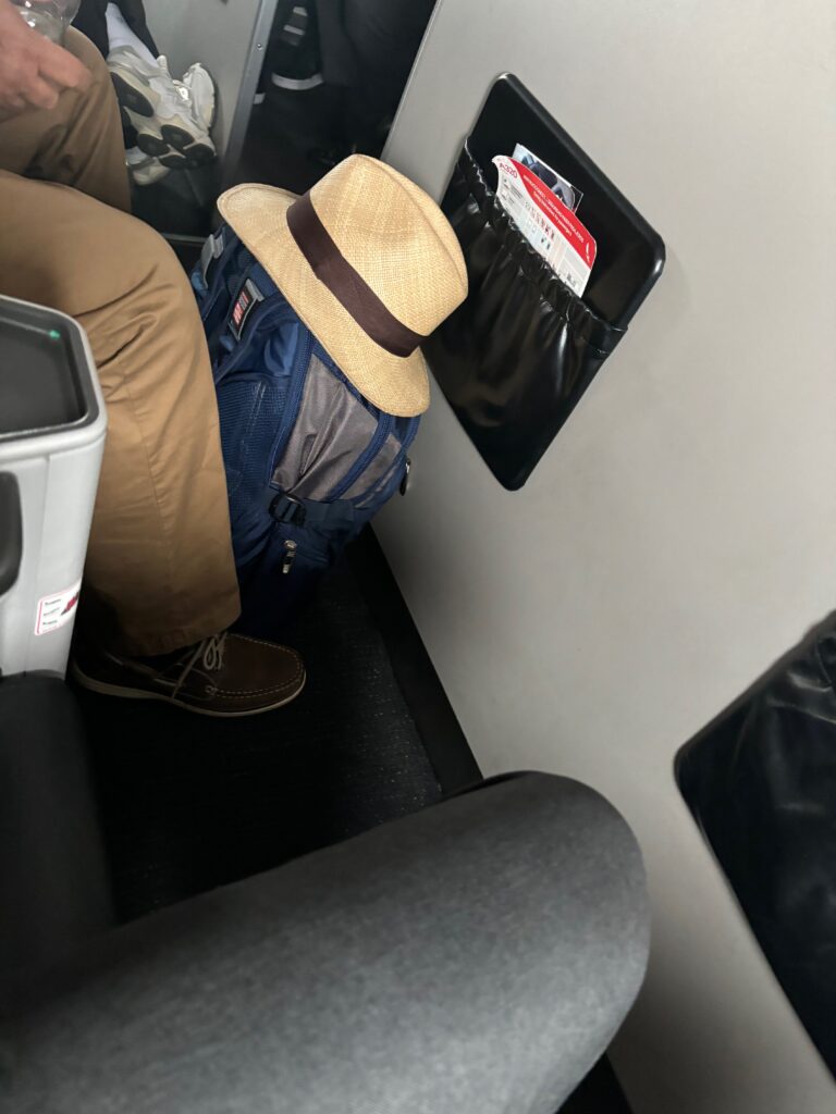 a person's legs and a hat on a backpack