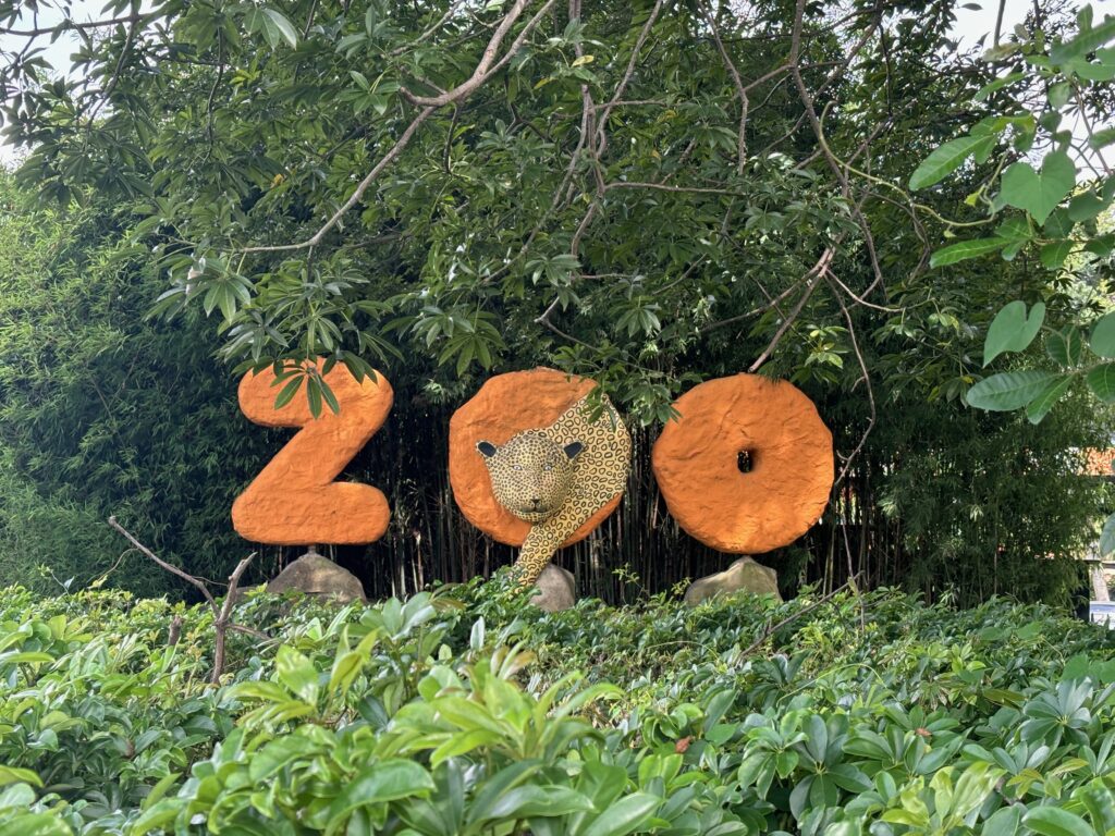 a sign with a leopard head and numbers in the middle of a forest