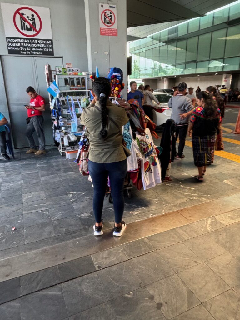 a woman standing in front of a rack of clothes