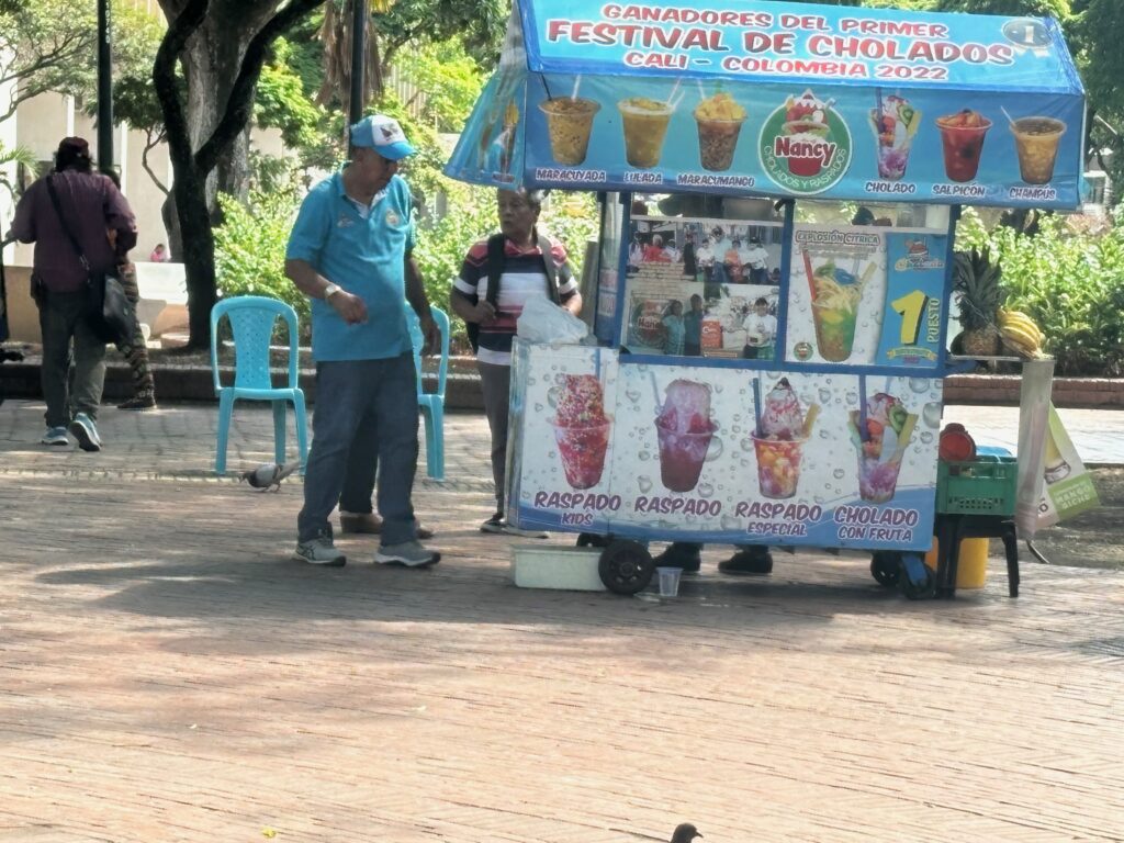 a man and woman standing next to a food cart