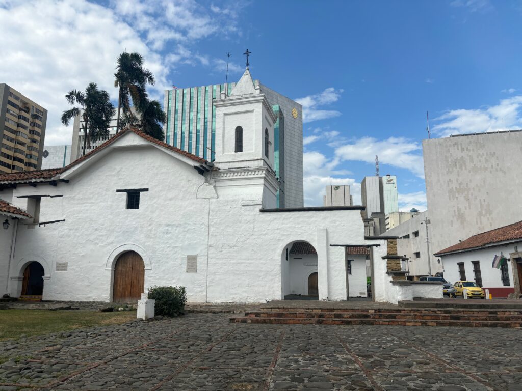 a white building with a tower and a brick walkway