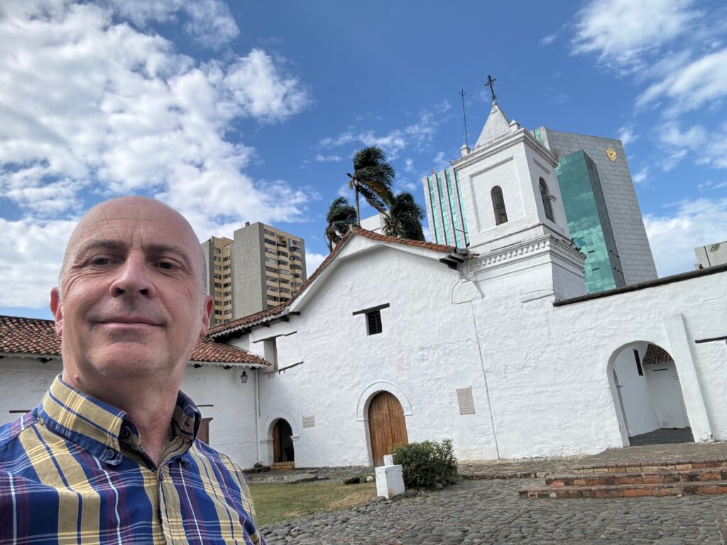 a man taking a selfie in front of a white building