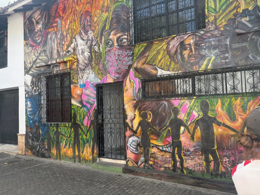 a wall with a mural of people and people