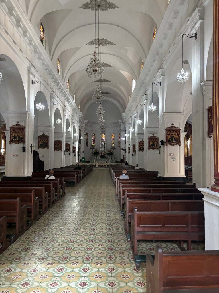 a church with many pews and a man sitting in the middle