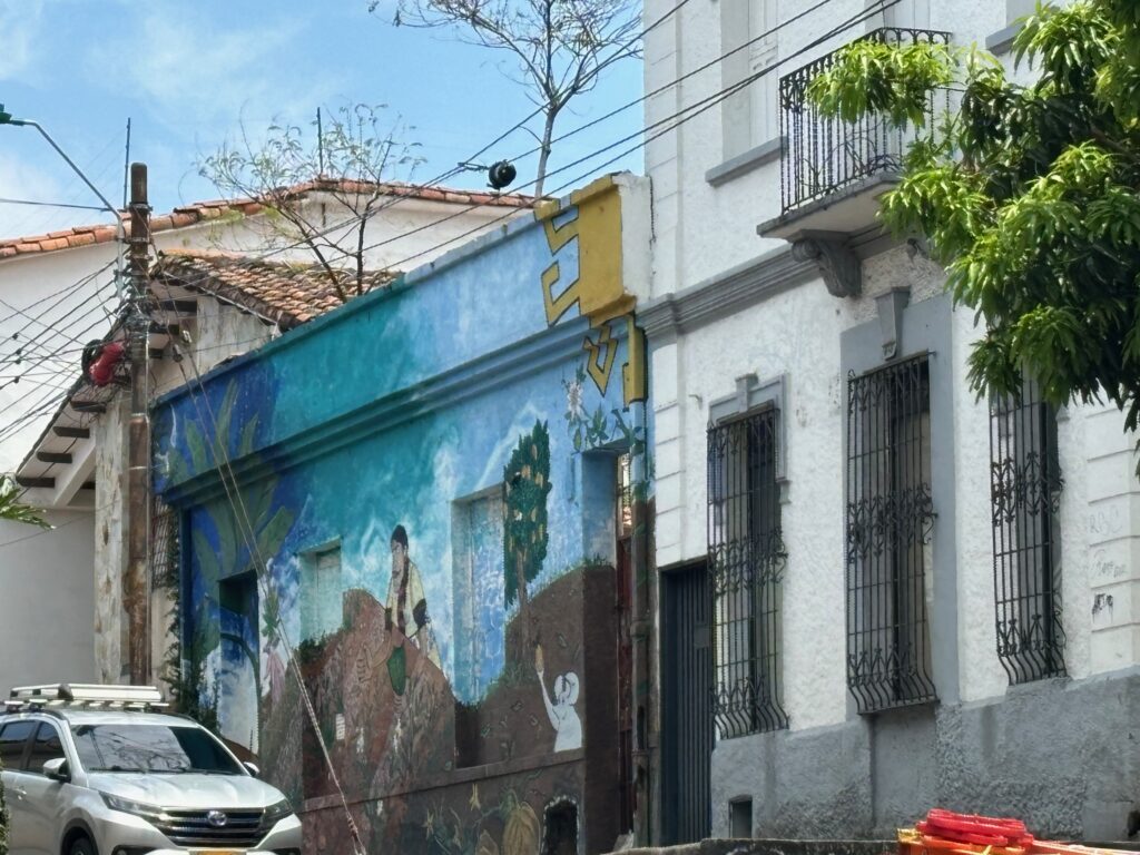 a street with cars and a mural on the side of a building