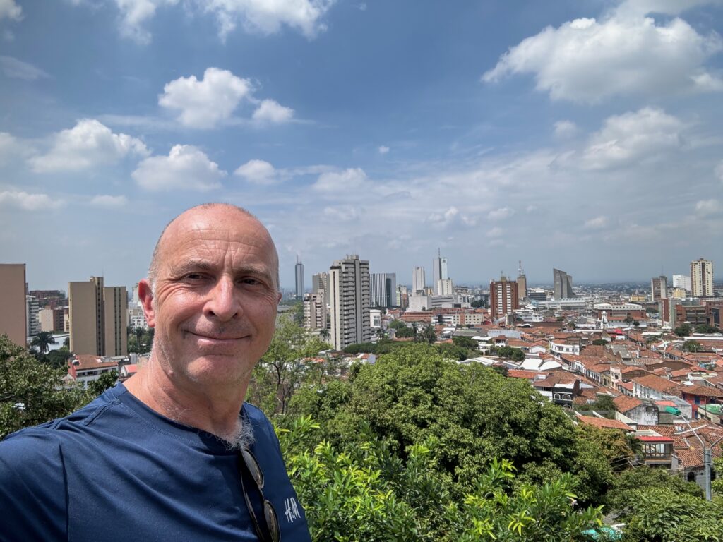 a man taking a selfie with a city in the background