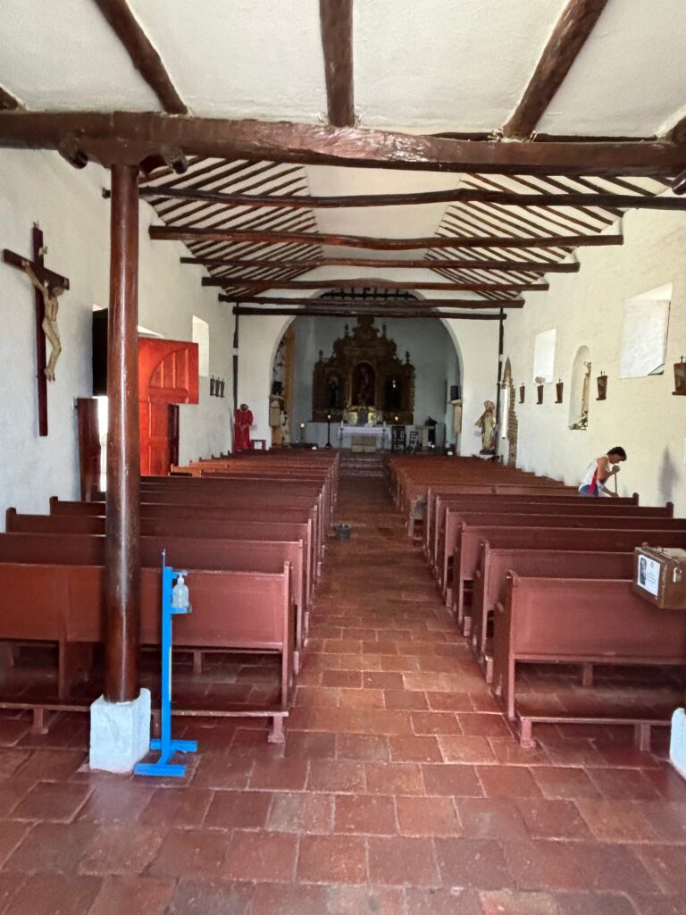 a room with benches and a cross in it