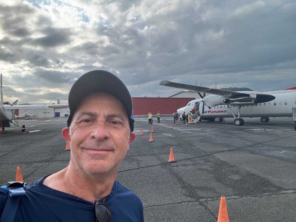 a man taking a selfie in front of an airplane