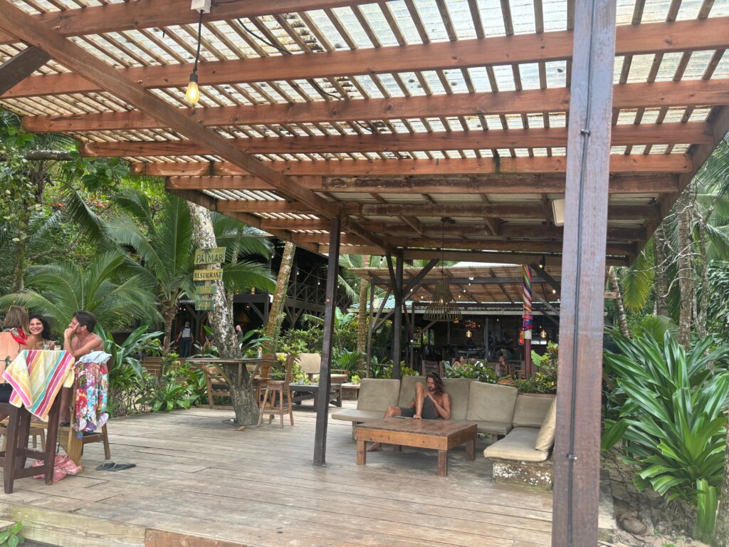 a person sitting on a couch under a wooden canopy