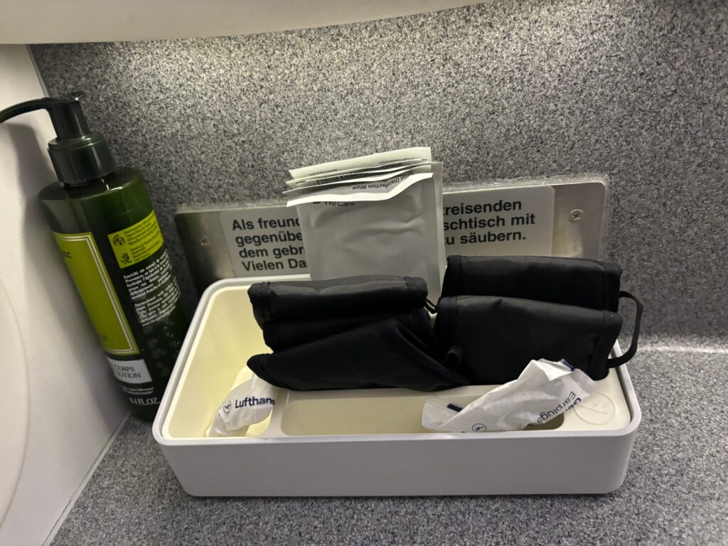 a white container with black gloves and a green spray bottle