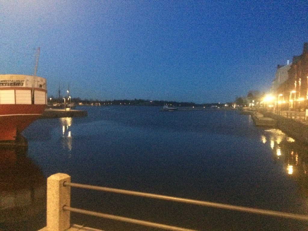 a body of water with a boat and a building in the background