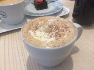 a cup of coffee with whipped cream and chocolate sprinkles