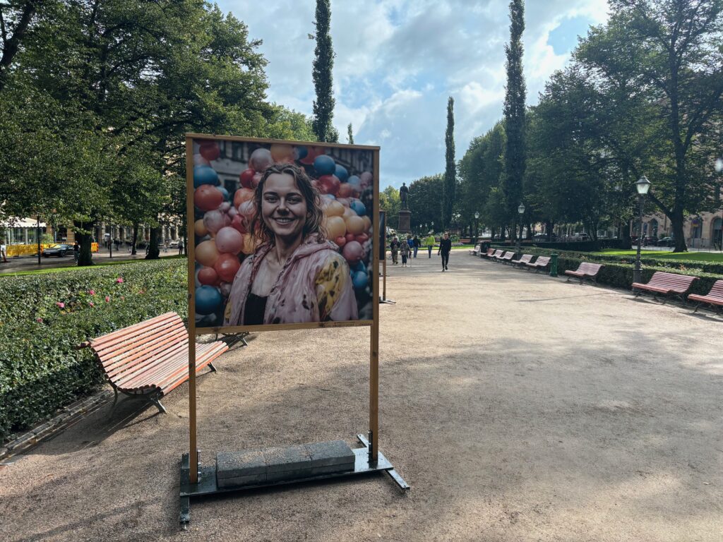 a poster on a stand in a park