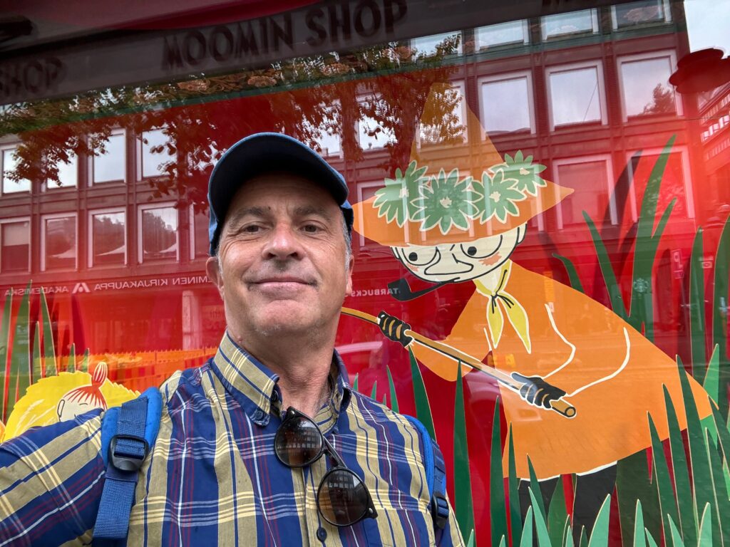 a man in a hat and sunglasses standing in front of a store