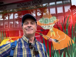 a man in a hat and sunglasses standing in front of a store