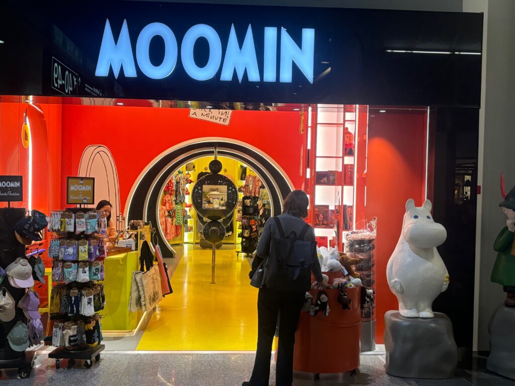 a store front with a sign and a person standing in front of it